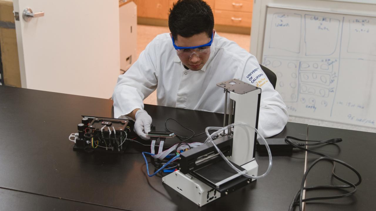 Student working with the student designed Bioprinter in the BioInnovation Lab.